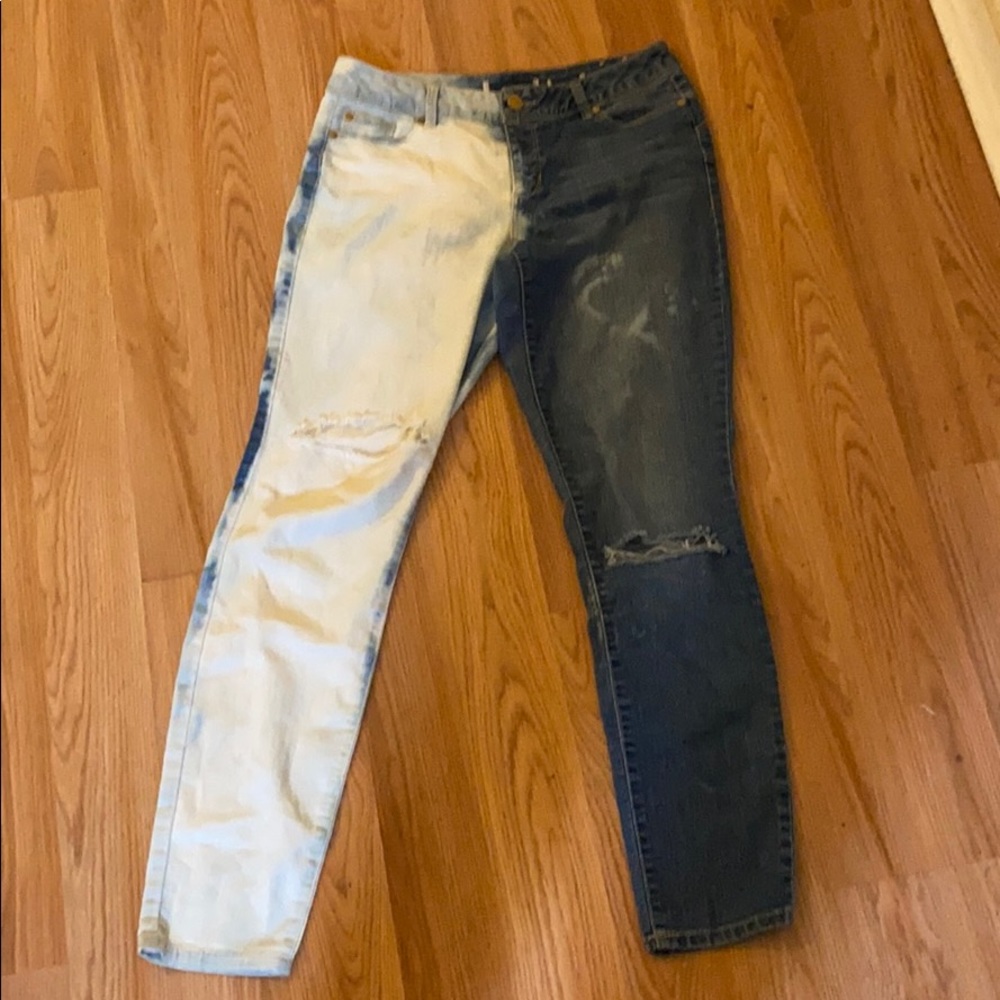 Half bleach dye jeans with rips in thigh and knee.